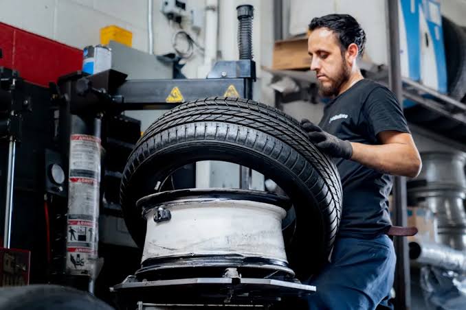 Technician replacing a worn tire
